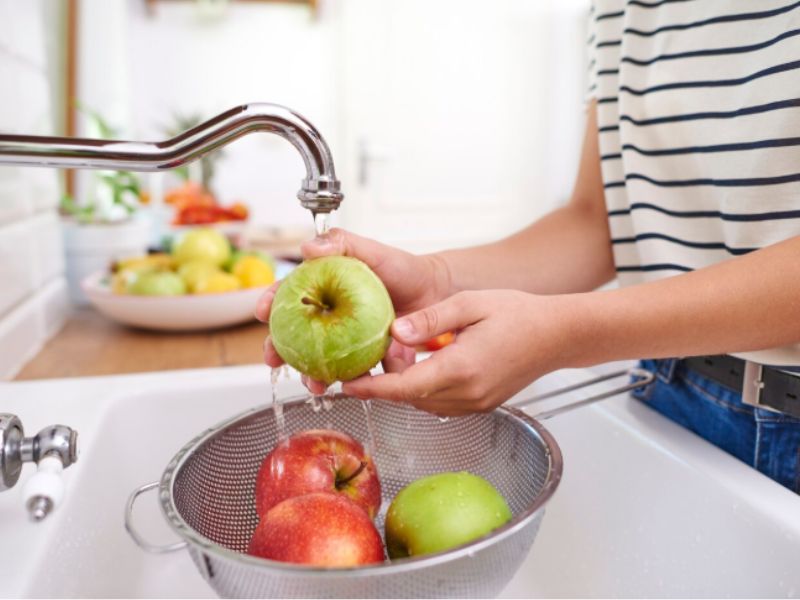 mulher lavando alimentos